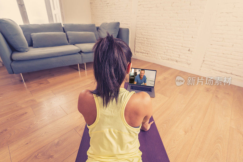 Woman exercising at home connected to online fitness class on laptop. Woman personal trainer coaching man on zoom teaching workout exercises in online body care, health and wellness business.